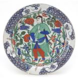 Turkish Iznik pottery plate hand painted with a figure amongst flowers, 31.5cm in diameter