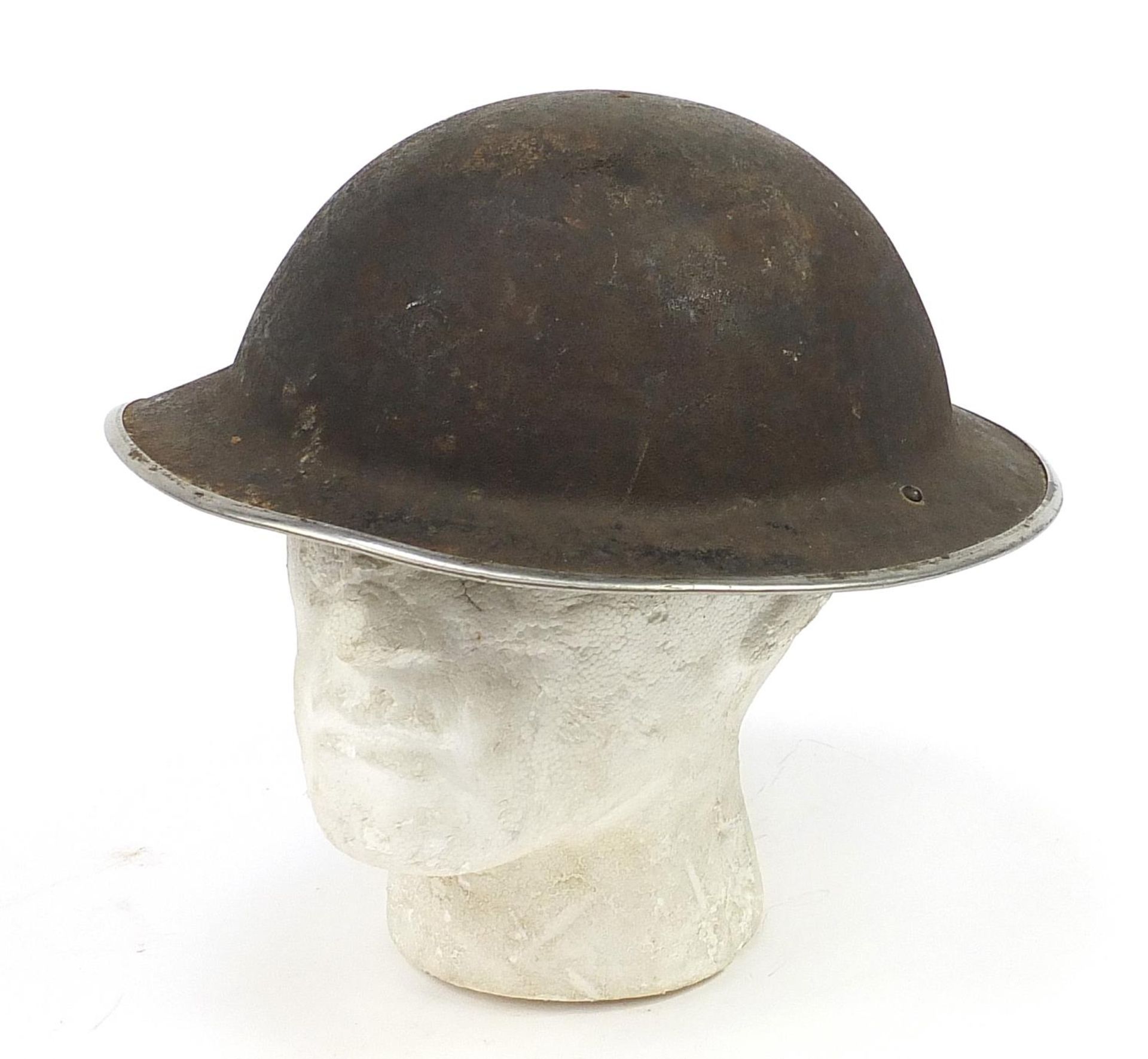 Military interest tin helmet with a bullet hole