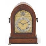Edwardian inlaid arch top bracket clock striking on a gong, the ornate dial having a silvered