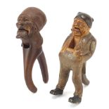 Two pairs of carved Black Forest figural nutcrackers including a falling Dutchman, the largest 20.