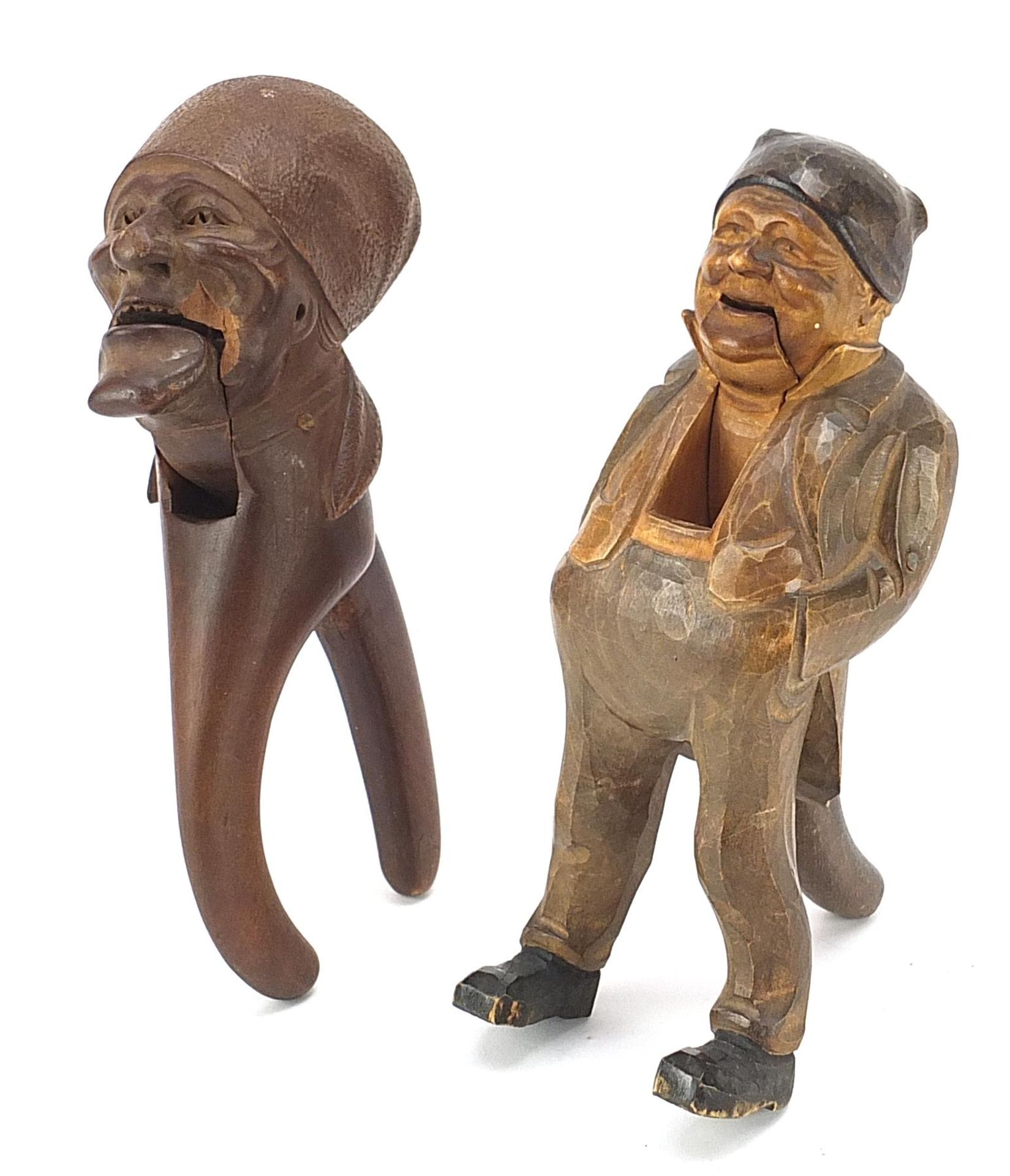 Two pairs of carved Black Forest figural nutcrackers including a falling Dutchman, the largest 20.