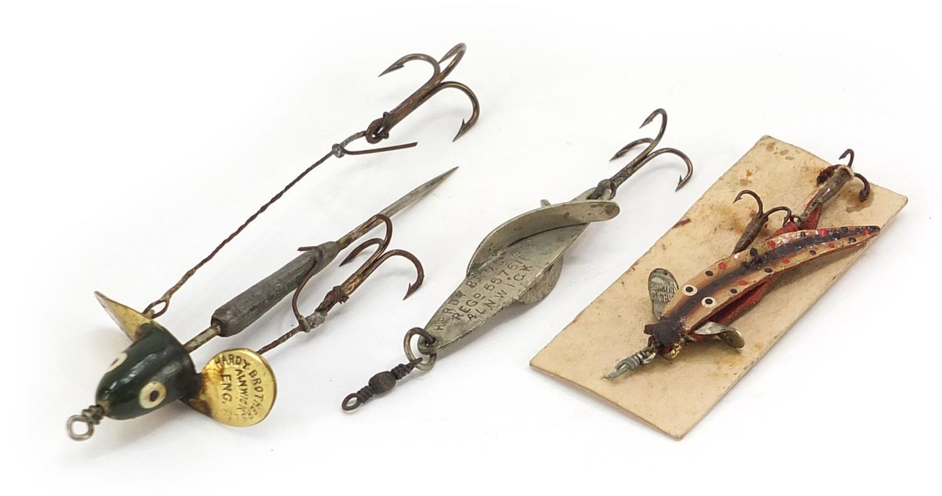 Three vintage Hardy Bros metal fishing lures, the largest numbered 15552?, 7.5cm in length