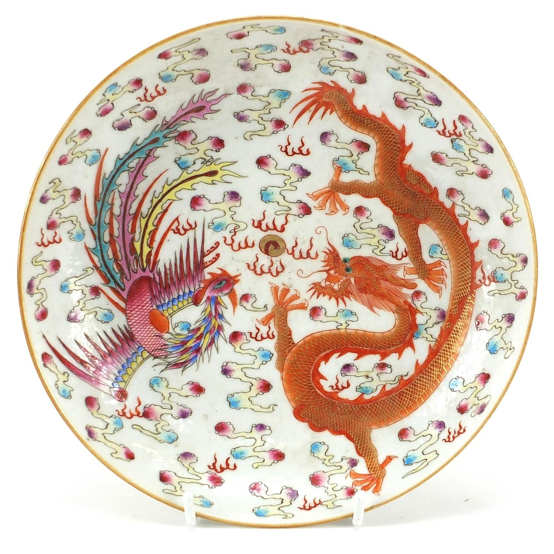 Chinese porcelain dish hand painted in the famille rose palette with a phoenix and dragon chasing