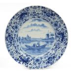 Delft blue and white charger hand painted with two fishermen in a boat before a windmill, 38cm in