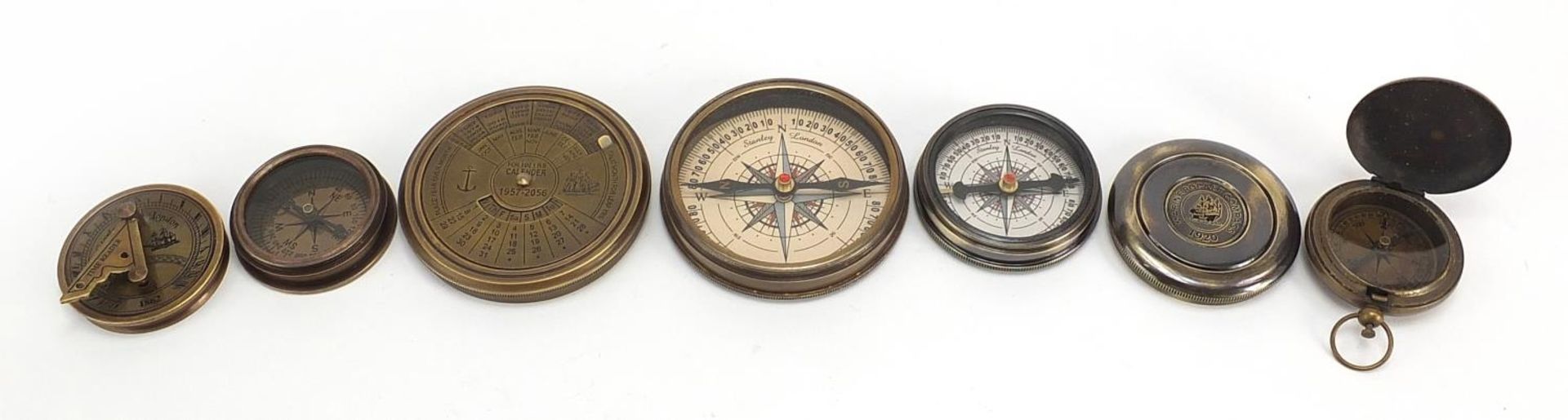 Four brass nautical interest compasses and sun dials, the largest 7.5cm in diameter
