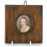 Oval hand painted portrait miniature of a female housed in a brass mount with oak frame, 5cm x 4cm