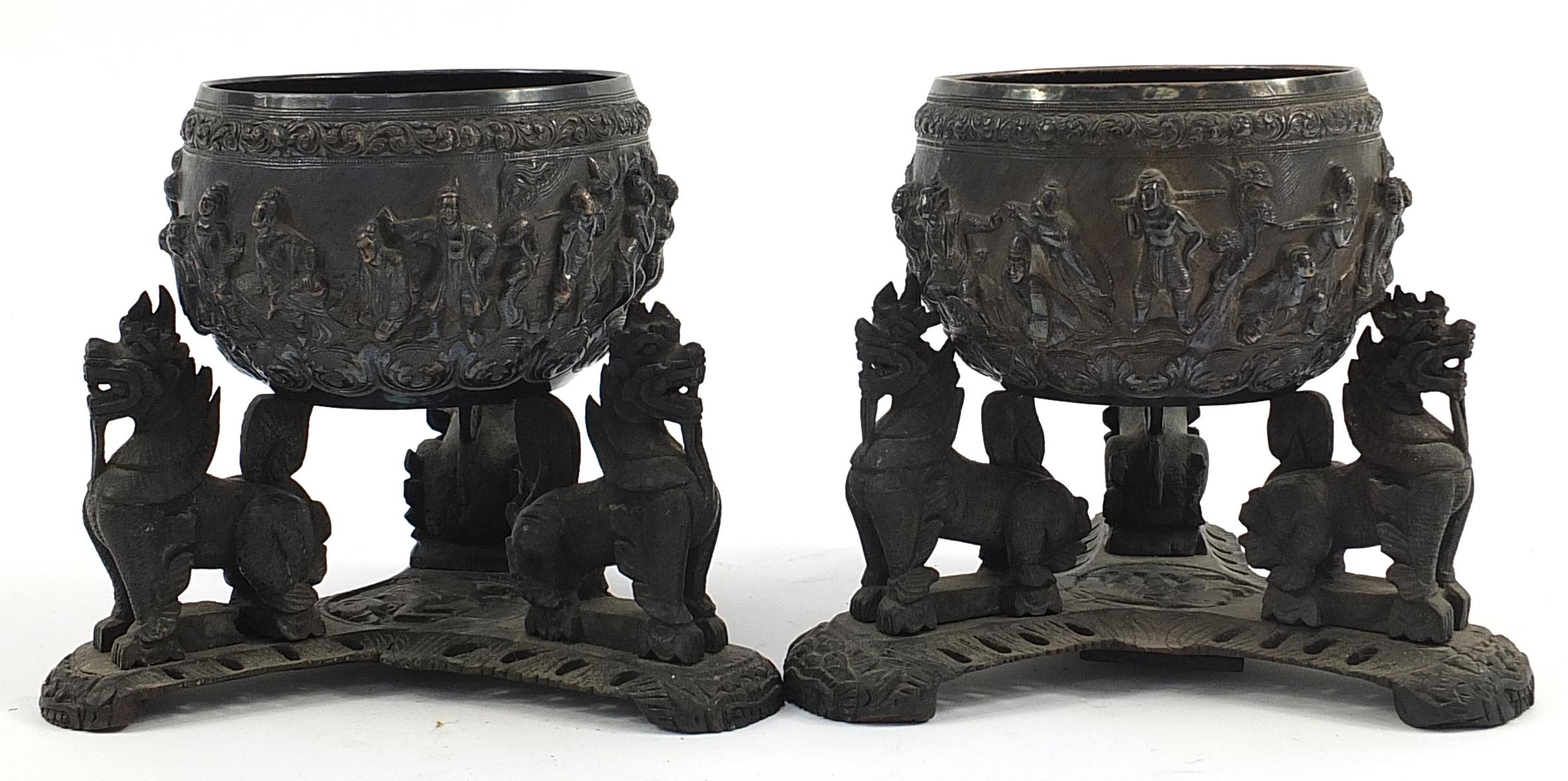 Pair of Burmese unmarked silver bowls embossed with figures raised on hardwood stands, each bowl - Image 2 of 3