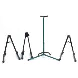Three folding metal guitar stands and an extendable green metal stand, the largest 75cm high