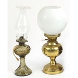 Brass oil lamp with milk glass shade and a smoked glass oil lamp, the largest 35cm high