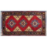 Red ground rug having an all over geometric floral design, 233cm x 127cm