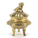 Chinese bronze three footed koro and cover with Foo dog knop, character marks to the base, 22cm high