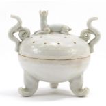 Chinese porcelain tripod censer and cover with twin handles and animal knop having a celadon