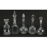Five antique and later cut glass decanters with stoppers, one with etched decoration, the largest