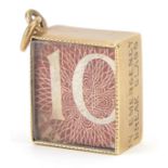 9ct gold emergency ten shilling note charm, 1.5cm in length, 2.6g