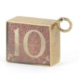 9ct gold emergency ten shilling note charm, 1.5cm in length, 2.6g