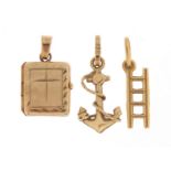 18ct gold ladder charm, 9ct gold anchor charm and 9ct gold opening bible charm, the largest 2.1cm