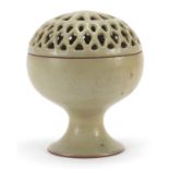 Chinese porcelain pedestal bowl with pierced cover having a celadon glaze, 15.5cm high