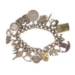 Silver charm bracelet with a selection of mostly silver charms including emergency one pound note,