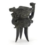 Chinese patinated bronze tripod wine vessel with animalia handle, impressed character marks to the