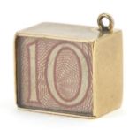 9ct gold emergency ten shilling note charm, 1.4cm in length, 2.5g