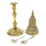 Metalware comprising a heavy gilt brass bell, candlestick and two silver spoons, the largest 23cm