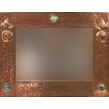 Attributed to Liberty & Co, Arts & Crafts beaten copper wall mirror inset with three Ruskin type