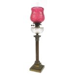 Victorian brass Corinthian column oil lamp with cranberry glass shade and clear glass reservoir,