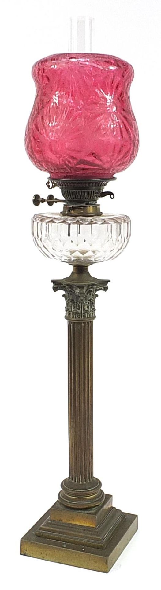 Victorian brass Corinthian column oil lamp with cranberry glass shade and clear glass reservoir,