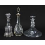 Three cut glass decanters including one with silver collar, the largest 34cm high