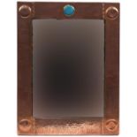 Attributed to Liberty & Co, Arts & Crafts beaten copper wall mirror with inset Ruskin type cabochon,