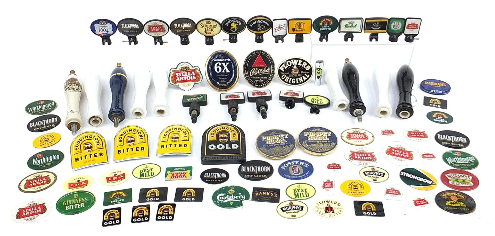 Collection of advertising bar beer pumps and beer pump labels including Stella, Kronenbourg, Bass