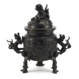 Japanese patinated bronze tripod incense burner with dragon handles and pierced lid, 21.5cm high