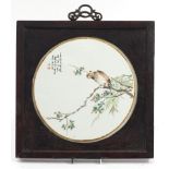 Chinese circular porcelain panel housed in a hardwood frame, the panel hand painted in the famille