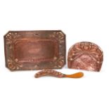 Arts & Crafts copper tray embossed with stylised flowers and a crumb tray with brush, the largest