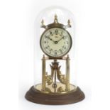 Kundo brass anniversary clock with enamelled dial housed under a glass dome, 29cm high