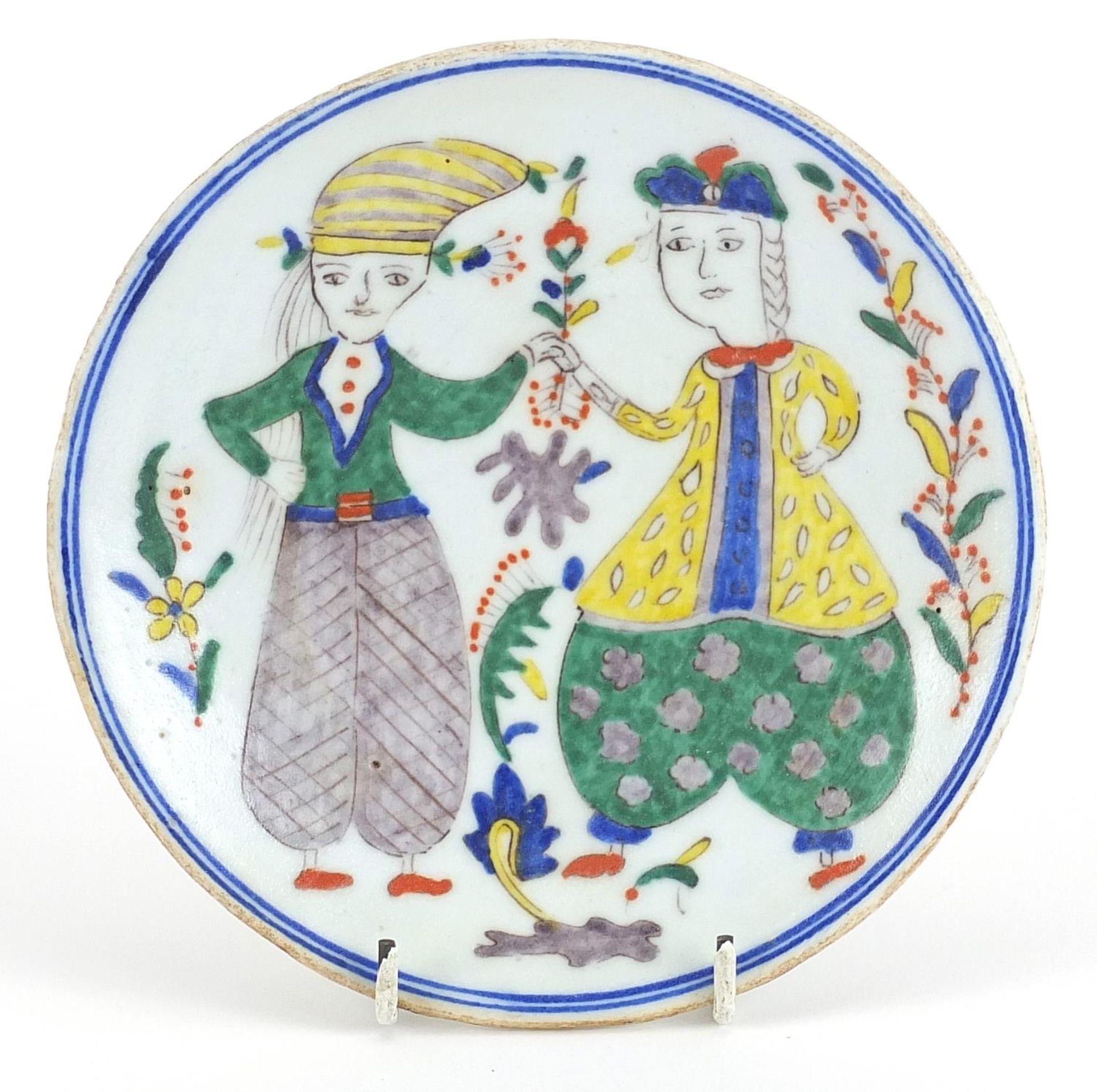 Turkish Kutahya pottery plate hand painted with two figures, 15.5cm in diameter