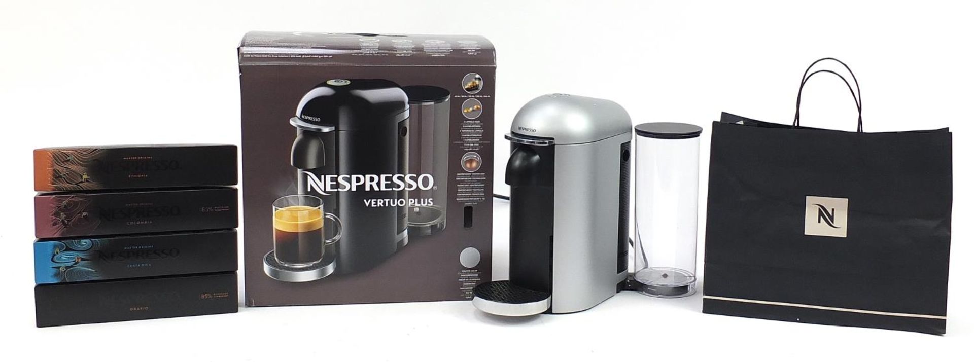 Nespresso Vertuo Plus coffee machine with box and four packets of pods