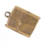 Antique unmarked gold locket in the form of a purse, engraved with flowers, (tests as 9ct gold)