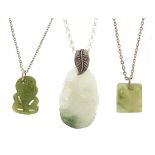 Three carved hardstone panels and white metal necklaces including New Zealand green jade example and