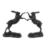 Pair of patinated bronze boxing hares raised on shaped marble bases, each 30cm high