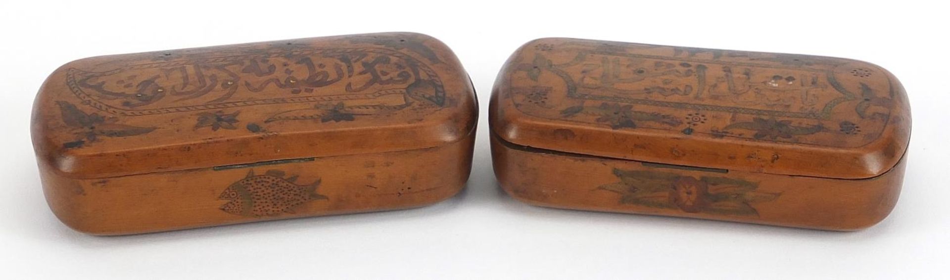 Pair of Islamic treen snuff boxes with calligraphy and flowers, each 11cm wide