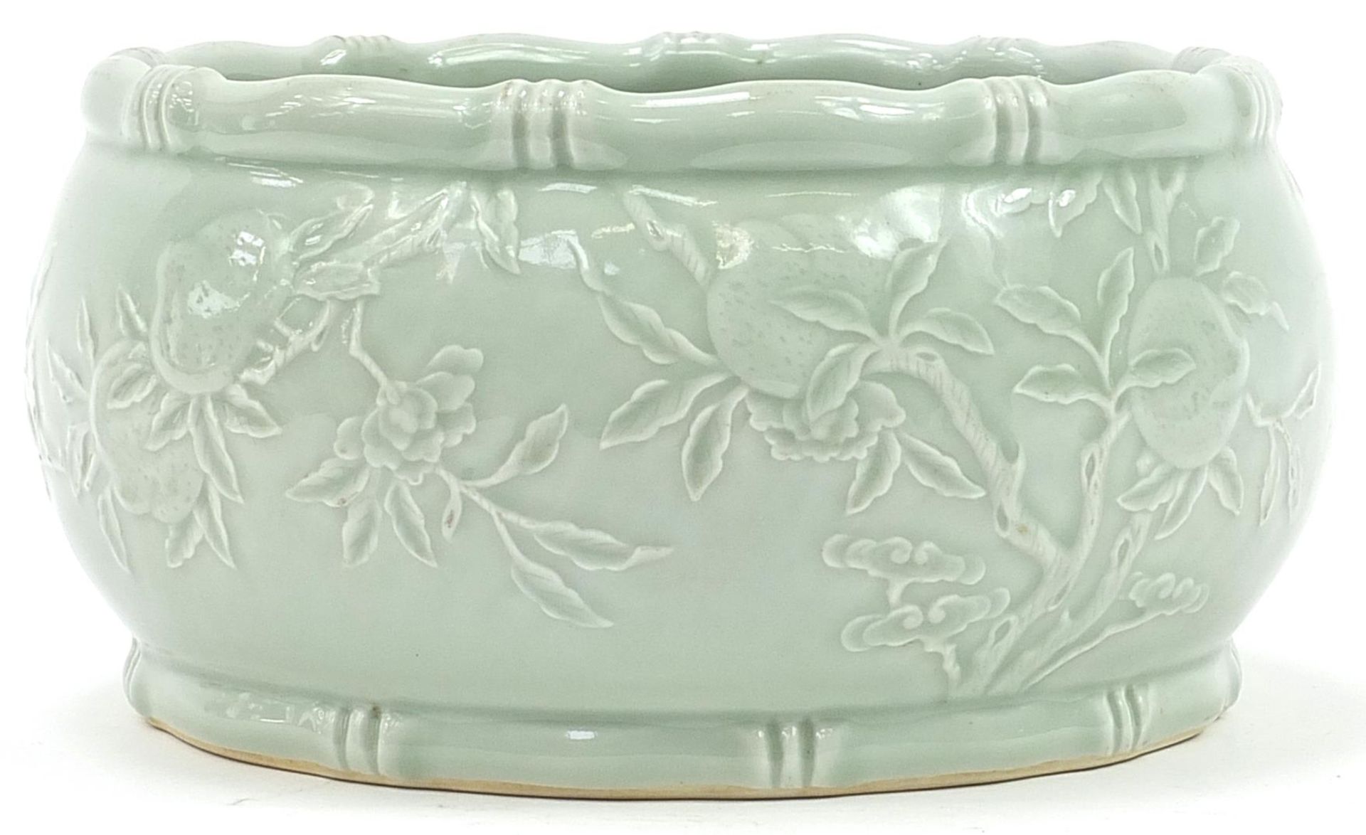 Good Chinese porcelain bowl having a celadon glaze decorated in low relief under glaze with peaches,