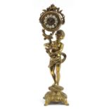 Large ornate brass mantle clock in the form of a semi nude boy holding an acanthus leaf, the dial