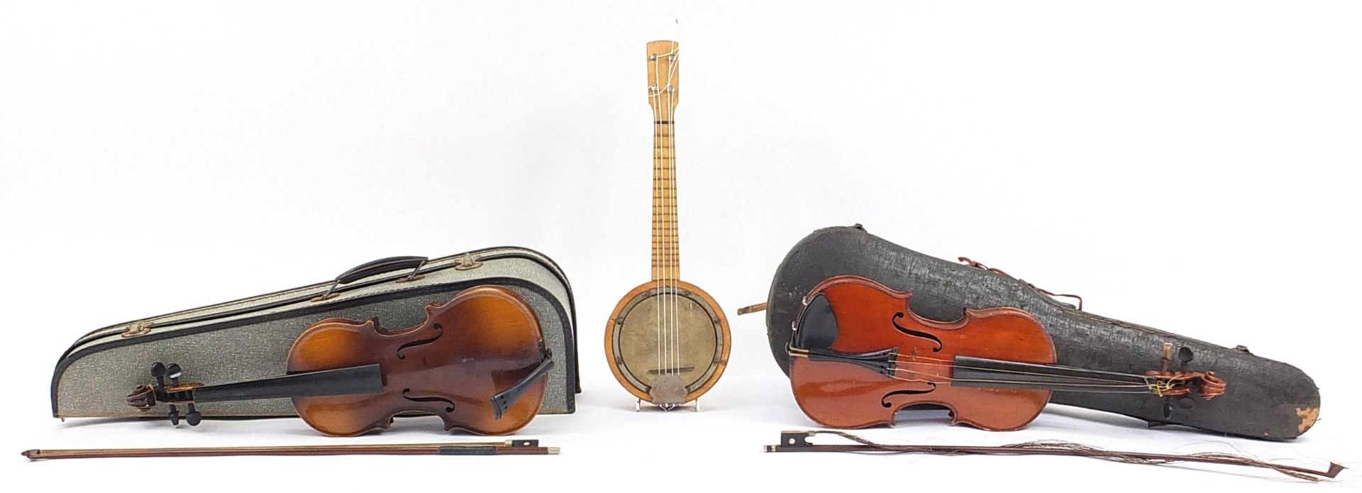 Two old wooden violins with bows and fitted cases and a Marseille banjolele