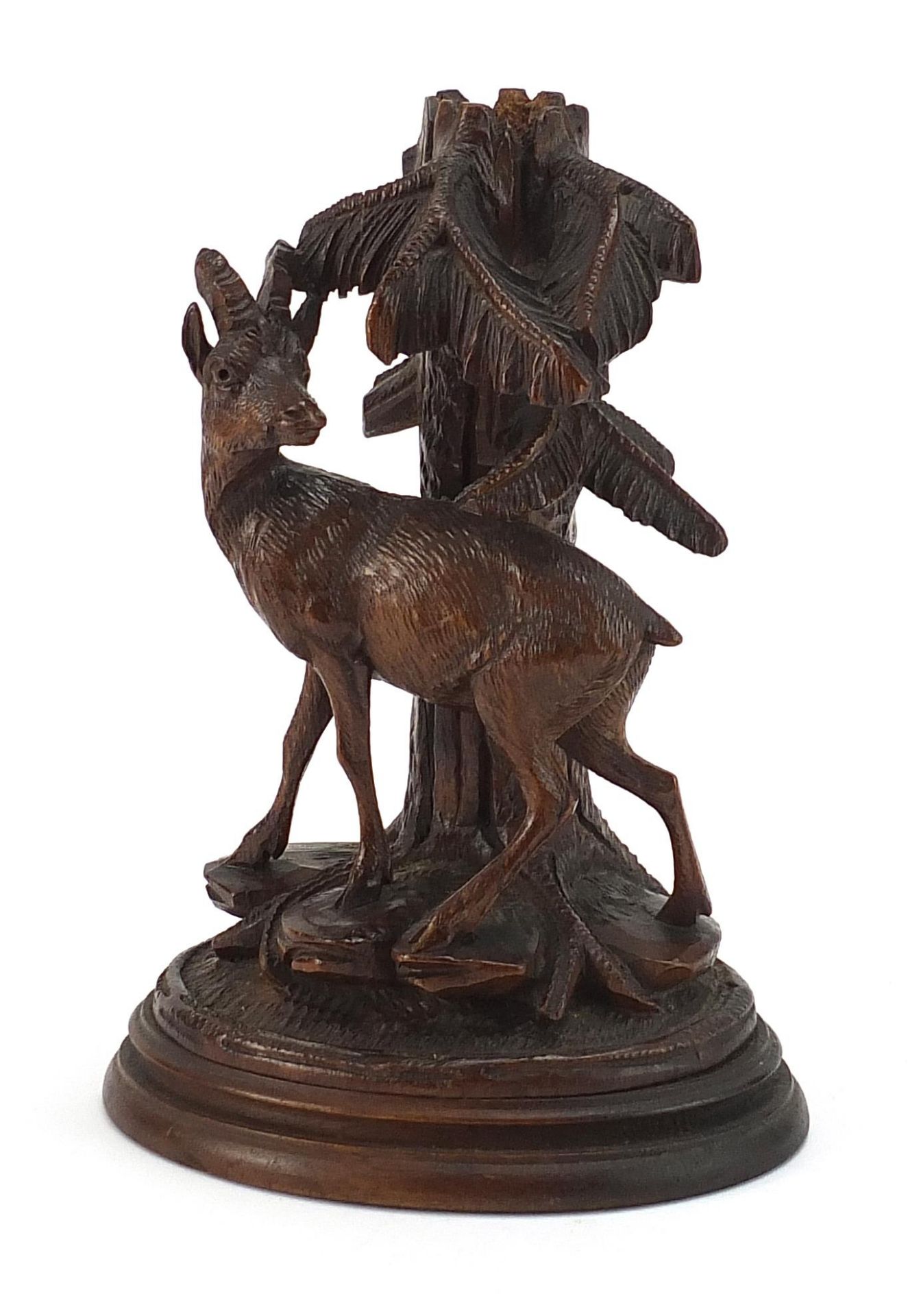 Carved Black Forest spill vase in the form of a deer beside a trunk, 21cm high