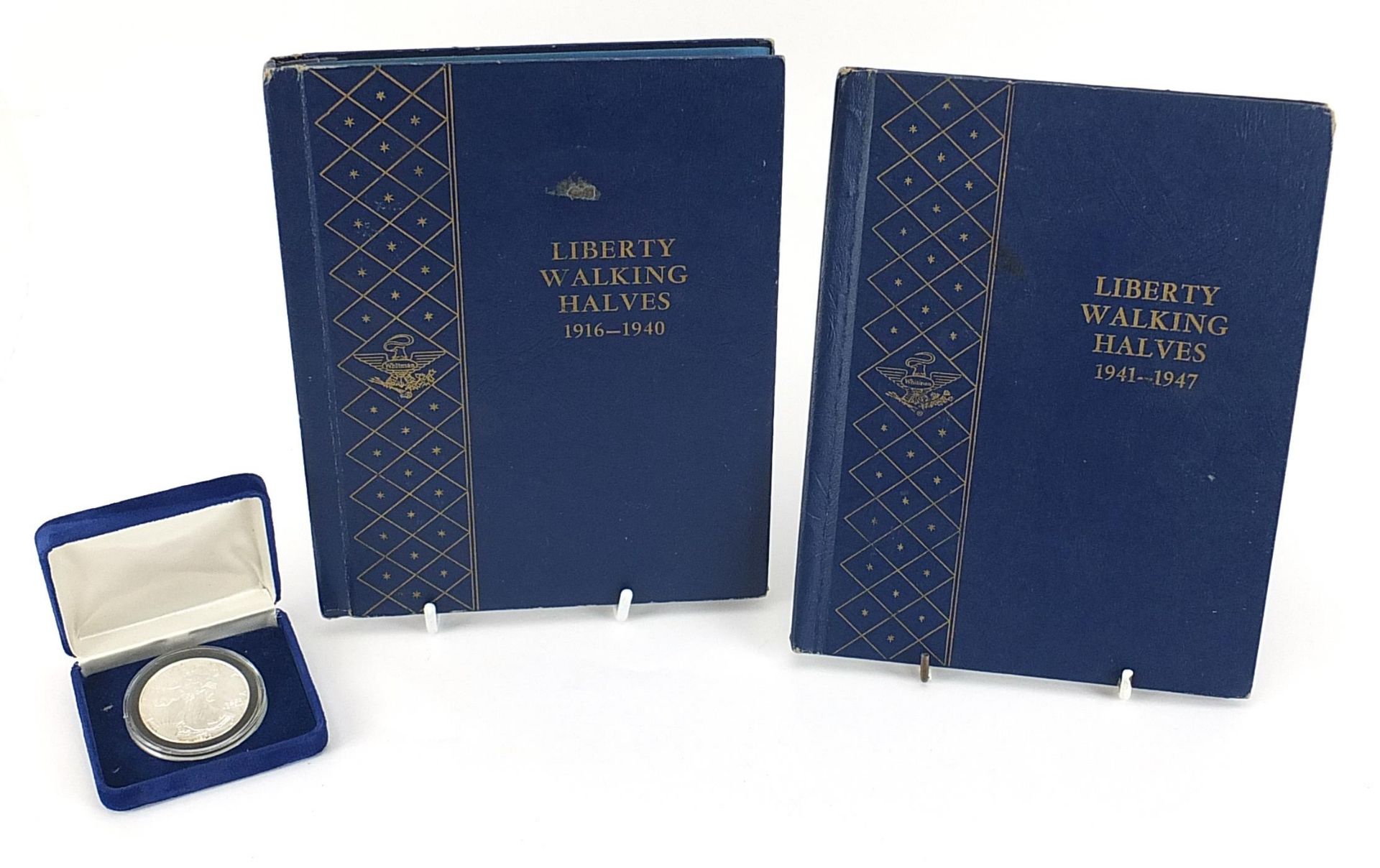 American coinage including Liberty Walking halves arranged in two albums and 1993 one ounce silver