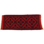 Rectangular red ground carpet runner having an abstract floral design and Greek key border, 165cm