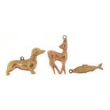 Three 9ct gold charms comprising Dachshund, deer and fish, the largest 2.5cm in length, total 3.8g