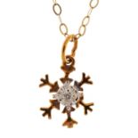 Yellow metal snowflake pendant set with a diamond on a 9ct gold necklace, 1.3cm in diameter and 35cm