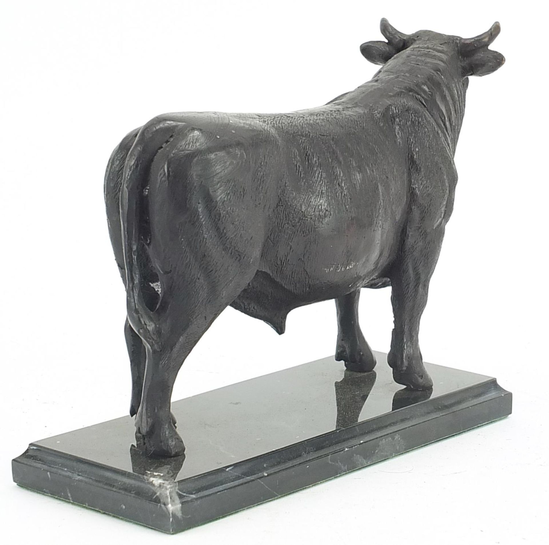 Patinated bronze bull raised on a rectangular black marble base, 24cm in length - Image 2 of 3